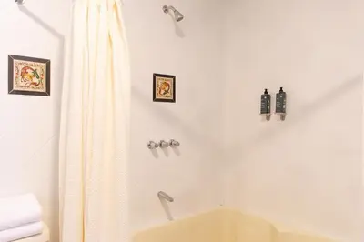 a white bathroom with a tub and a shower curtain at Tariq Sacred Valley in Urubamba