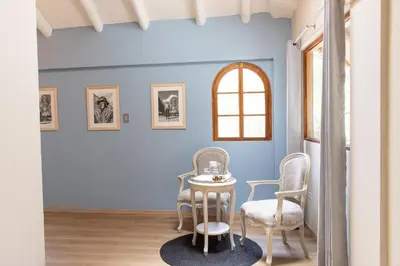 a table and chairs in a room with blue walls at Tariq Sacred Valley in Urubamba