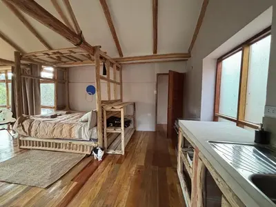 a bedroom with a bed in a room with wooden floors at Casa de campo Yoga Retreat in Urubamba