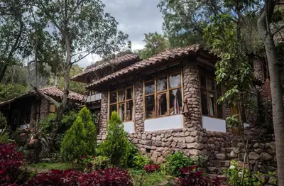 a stone house in the middle of a garden at Casa de campo Yoga Retreat in Urubamba