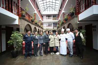 a group of people posing for a picture in a building at Munay Wasi Inn in Cusco