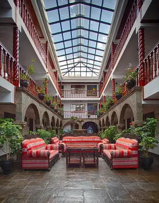 a large room with couches and tables in a building at Munay Wasi Inn in Cusco