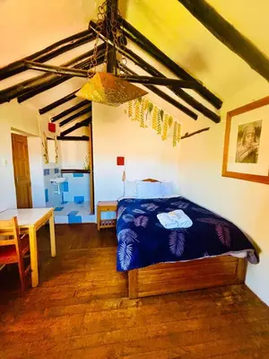 a bedroom with a bed and a table in a room at La Casa de Campo in Cusco