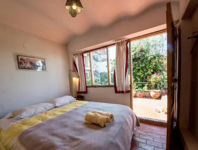 a bedroom with a large bed and a large window at La Casa de Campo in Cusco