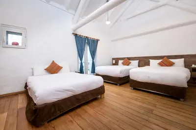 a bedroom with three beds in a room at Inkarri Cusco in Cusco