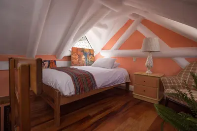 a bedroom with a bed and a window and a chair at Inkarri Cusco in Cusco