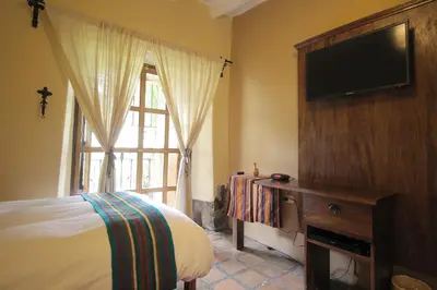 a bedroom with a bed and a tv and a window at 