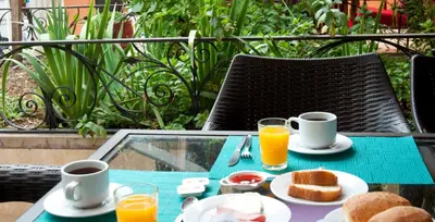 a table with breakfast foods and cups of orange juice at Hosteria de Anita in Cusco