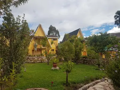 a yellow house with a garden in front of it at Amaru Valle Hotel in Urubamba
