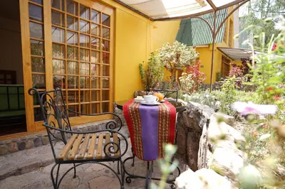 a patio with a table and two chairs and a table and chairs at Amaru Valle Hotel in Urubamba