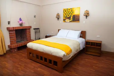 a bedroom with a large bed and a fireplace at Amaru Valle Hotel in Urubamba
