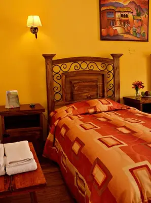 a bedroom with a bed and a table with towels at Hostal Mallqui in Cusco