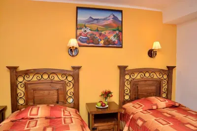 two beds sitting next to each other in a room at Hostal Mallqui in Cusco