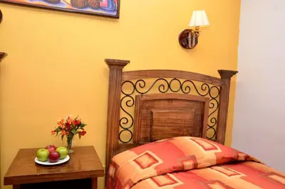 a bedroom with a bed and a table with fruit on it at Hostal Mallqui in Cusco