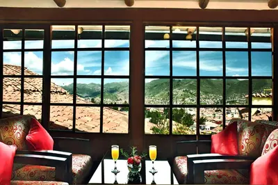 a room with two chairs and a view of a mountain at Amaru Colonial in Cusco