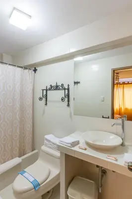 a bathroom with a sink and a toilet and a mirror at Amaru Colonial in Cusco