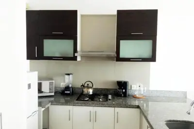 a kitchen with white cabinets and black counter tops at Apartamento dúplex exclusivo y céntrico in Lima