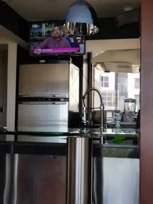 a kitchen with a sink and a tv above it at Miraflores Frente al Mar in Lima