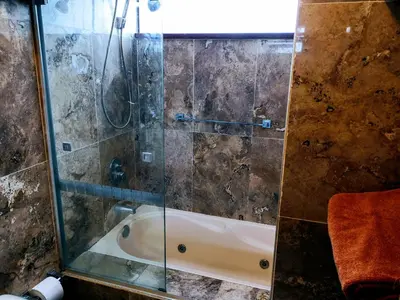 a bathroom with a shower with a bath tub at Miraflores Frente al Mar in Lima