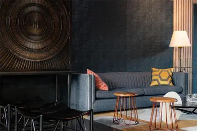 a living room with a blue couch and stools at Hyatt Centric San Isidro Lima in Lima