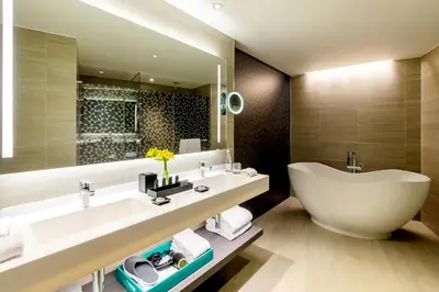 a bathroom with a large white tub and a sink at Hyatt Centric San Isidro Lima in Lima
