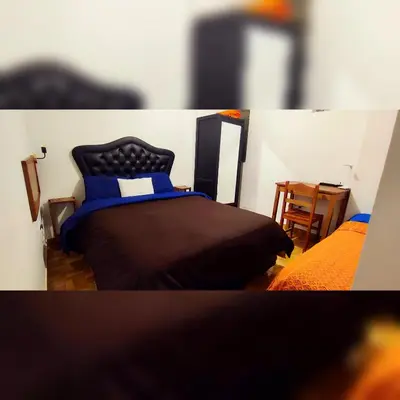 a bedroom with a black bed with a blue pillow at Antarki Apartment in Cusco