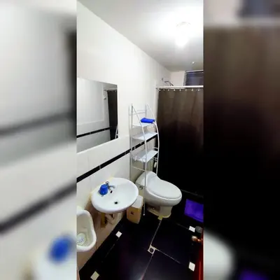 a bathroom with a white toilet and a sink at Antarki Apartment in Cusco