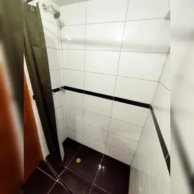 a small bathroom with a white tiled wall at Antarki Apartment in Cusco