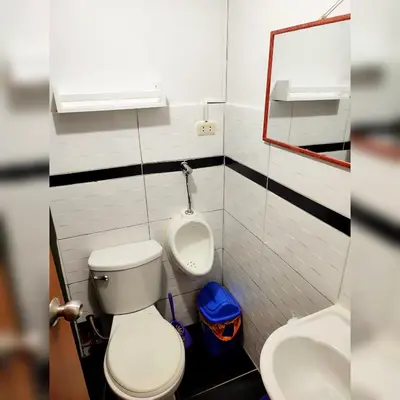 a bathroom with a toilet and a sink and a urinal at Antarki Apartment in Cusco