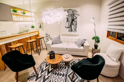 a living room with a white couch and chairs at Casa Azul in Lima