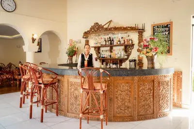 a man sitting at a bar in a room at Hotel Agustos Urubamba in Urubamba