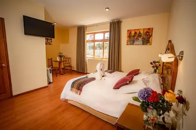 a bedroom with a large bed with flowers on it at Hotel Agustos Urubamba in Urubamba