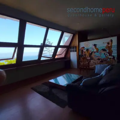 a living room with large windows and a couch at Second Home Peru in Lima
