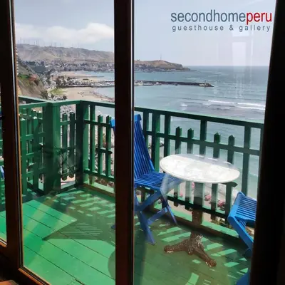 a balcony with a table and chairs and the ocean at Second Home Peru in Lima