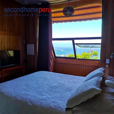 a bedroom with a bed and a large window at Second Home Peru in Lima