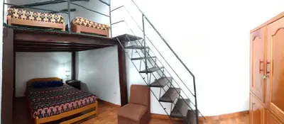 a bedroom with a bunk bed and a staircase at Chelitos Backpacker in Cusco