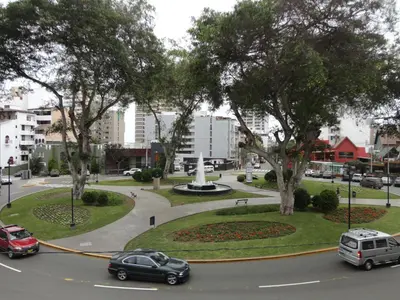a street with cars on a road with trees at Miraflores Bello Apartamento in Lima