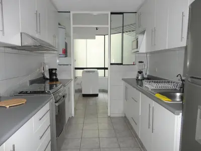 a kitchen with white cabinets and white appliances at Miraflores Bello Apartamento in Lima