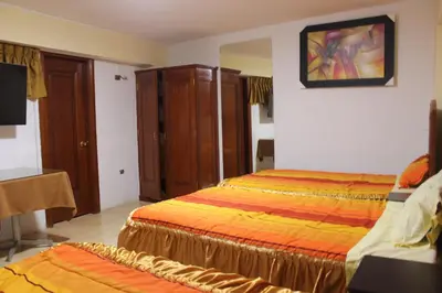 a hotel room with two beds and a tv at Tinoco Apart Hotel in Ayacucho