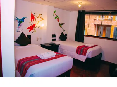 a room with two beds with birds on the wall at Peru Coca B&B Machupicchu in Machu Picchu