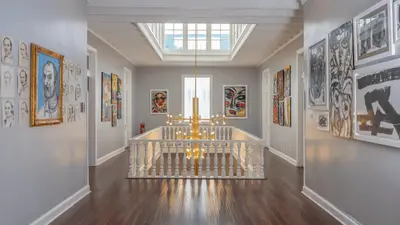 a hallway with a chandelier and paintings on the walls at Casa Republica Barranco Boutique Hotel in Lima
