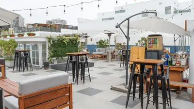 a patio with bar stools and tables and an umbrella at Casa Republica Barranco Boutique Hotel in Lima
