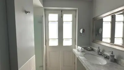 a white bathroom with a sink and a mirror at Casa Republica Barranco Boutique Hotel in Lima