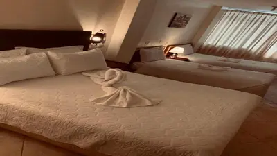 a hotel room with a bed with a towel on it at Margarita's House Machupicchu in Machu Picchu
