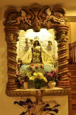 a altar with a statue of a woman with flowers at Awki´s Dream Hotel in Cusco