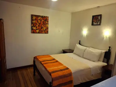 a hotel room with a bed and a painting on the wall at Departamentos Cusco in Cusco