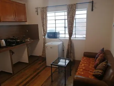 a living room with a couch and a table and a kitchen at Departamentos Cusco in Cusco