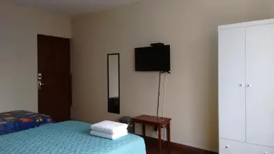 a bedroom with a bed and a tv on the wall at Cozy and Comfortable Home in MIRAFLORES in Lima