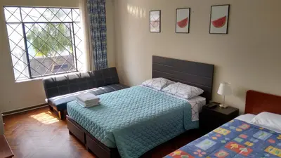 a bedroom with two beds and a couch and a window at Cozy and Comfortable Home in MIRAFLORES in Lima