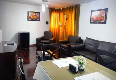 a living room with leather chairs and a table at Inkari Apart Hotel in Lima